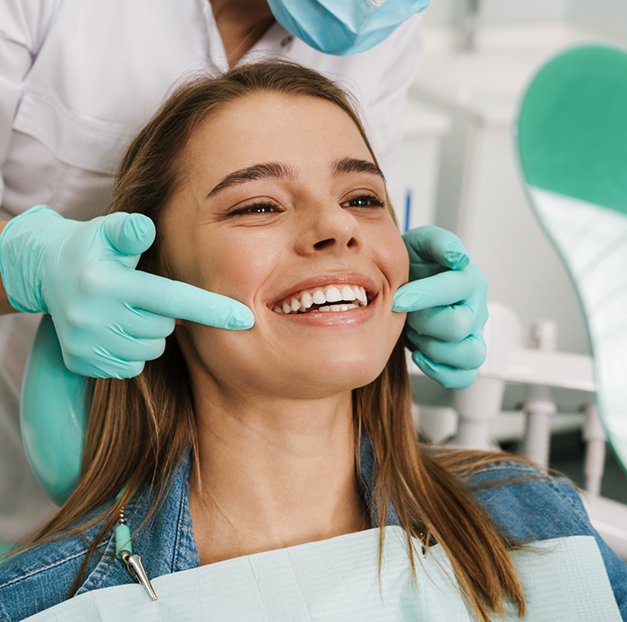 Dentist pulling back patients lips to show smile