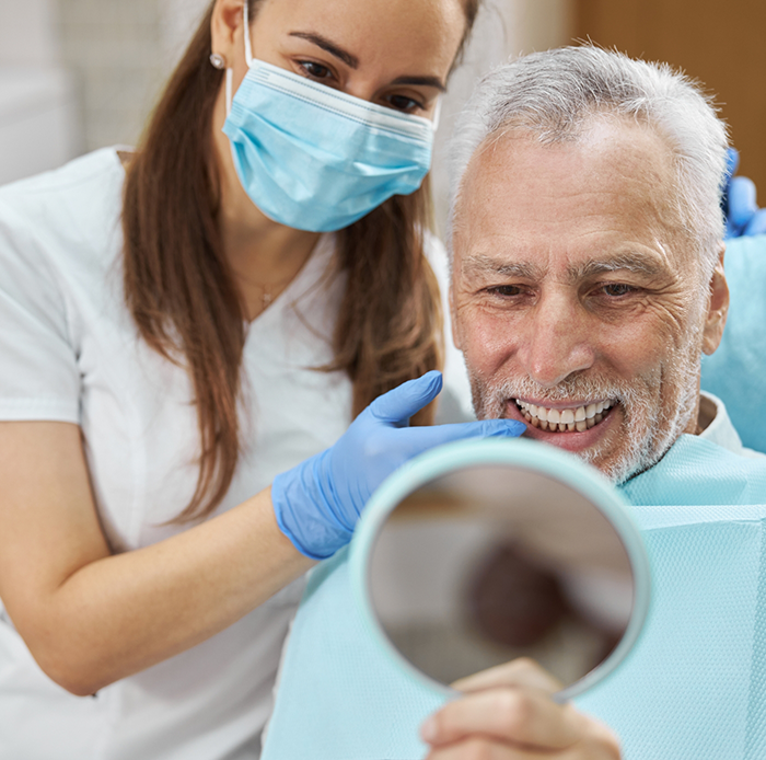 Dentist showing patient new smile in mirror