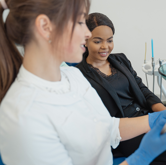 Female dentist talking to female patient