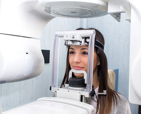 Female patient about to have mouth scanned with cone beam scanner