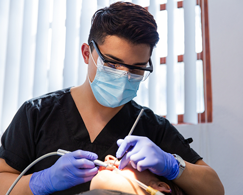 Dentist wearing mask treating patient