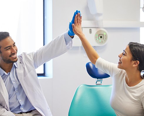 Patient giving high-five to her dentist