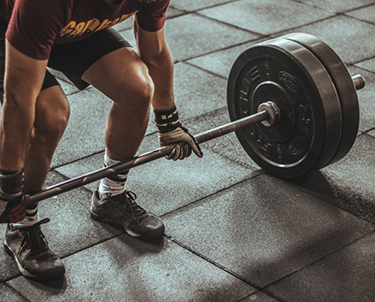 Man bending down to lift weights