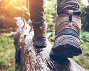 Close up of person with boots walking on log