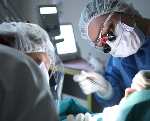 Dentists in masks performing full mouth reconstruction