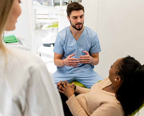 Dentists talking to a female dental patient