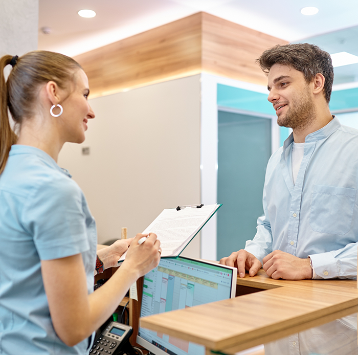 Female dental team member talking to male patient