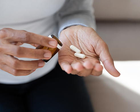 Close up of person pouring pills into their hand