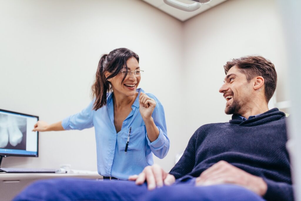 Dentist and patient smiling at each other